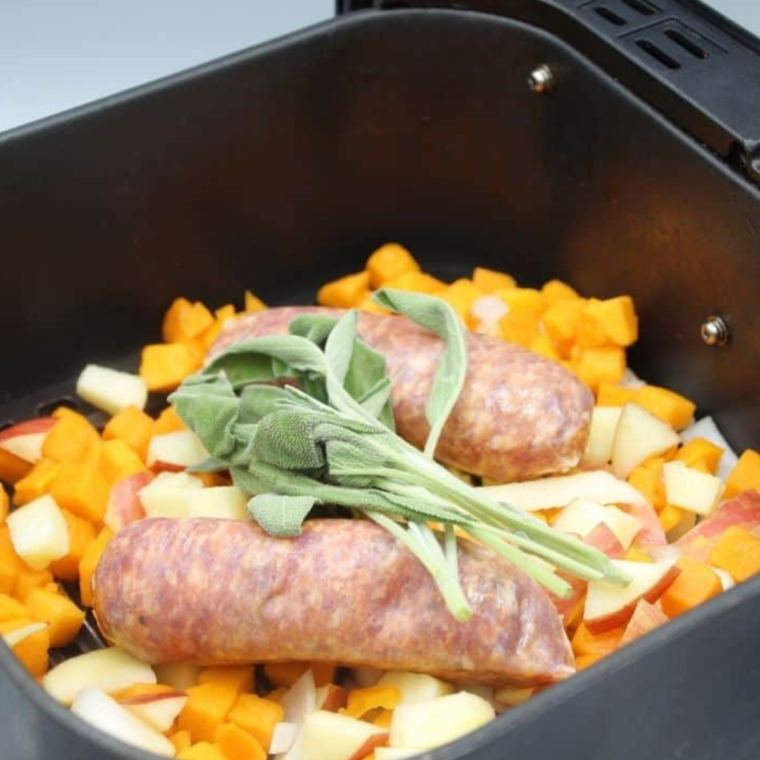 Air Fryer Sausages With Roasted Apples and Butternut Squash in air fryer basket.