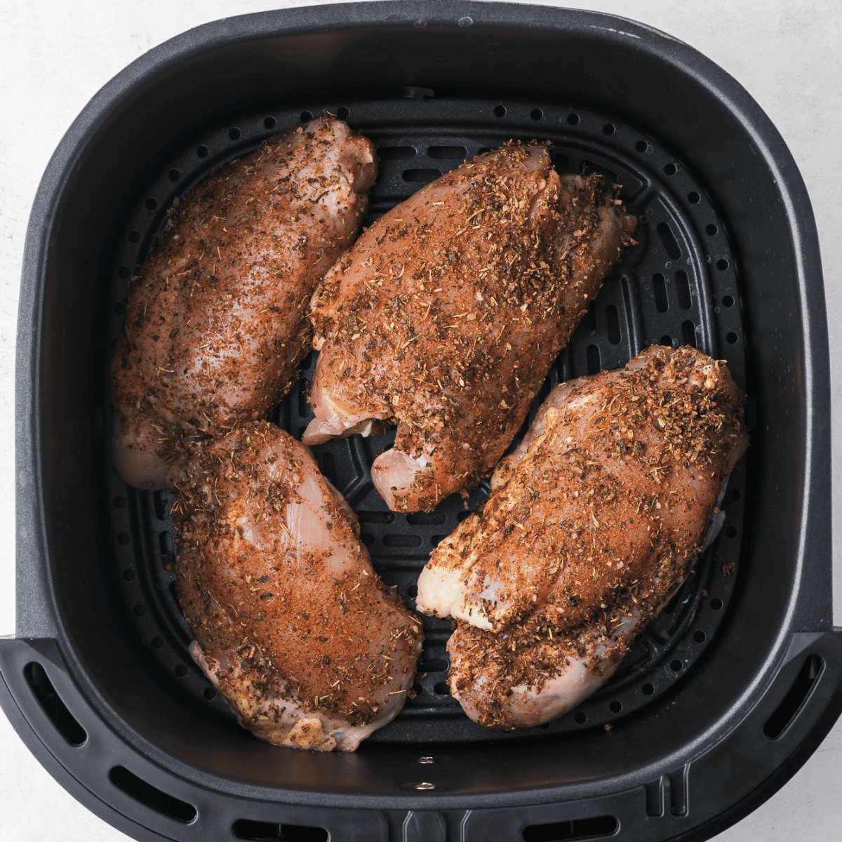 Place chicken thighs, seasoned in the air fryer basket, single layer.