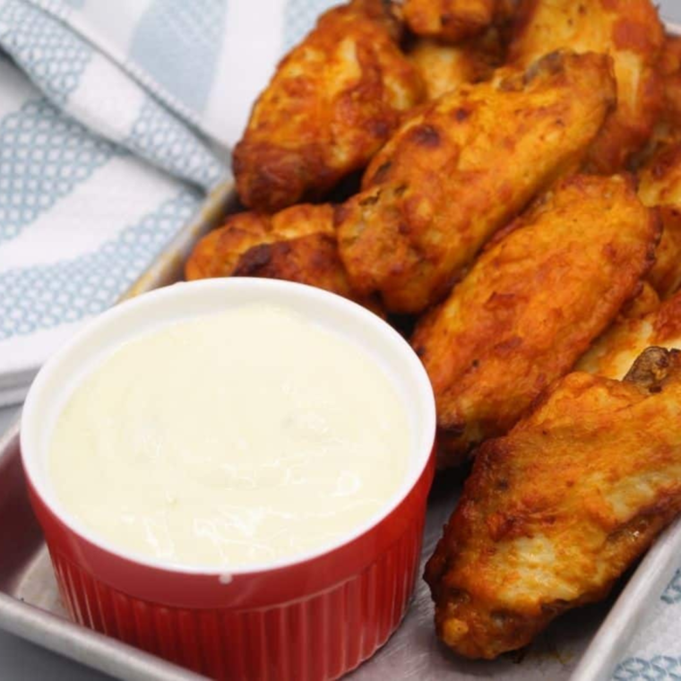 Cooked Tyson Chicken Wings on a plate with dipping sauce.