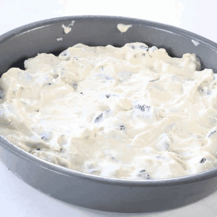 Cheesecake baking in the oven with smooth, creamy top.
