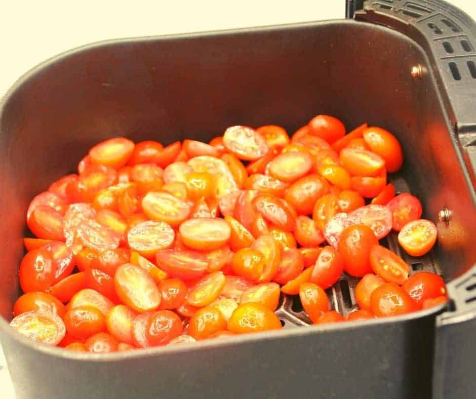 closeup: prepared tomato halves in air fryer basket