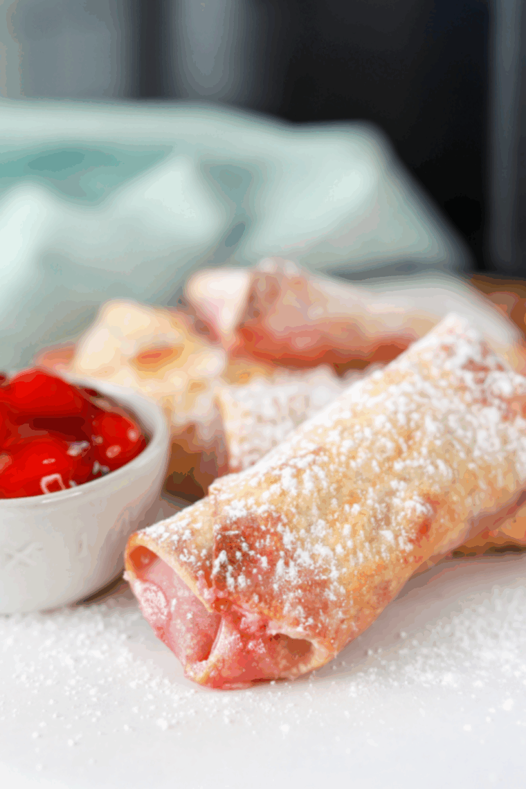 Golden-brown Air Fryer Cherry Cheesecake Egg Rolls with gooey cherry and cream cheese filling.
