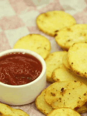 Golden, crispy air fryer potato chips coated in tangy ranch seasoning, served in a bowl.
