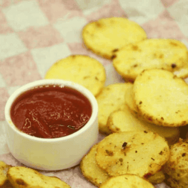 Golden, crispy air fryer potato chips coated in tangy ranch seasoning, served in a bowl.