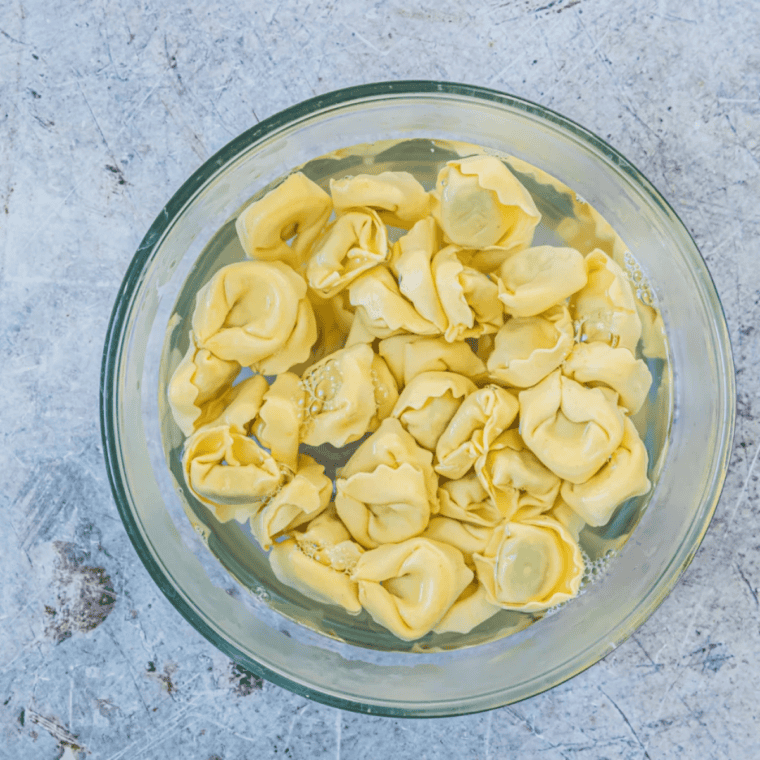 Soften the Frozen Tortellini
Frozen tortellini soaking in a heatproof bowl of just-boiled hot water