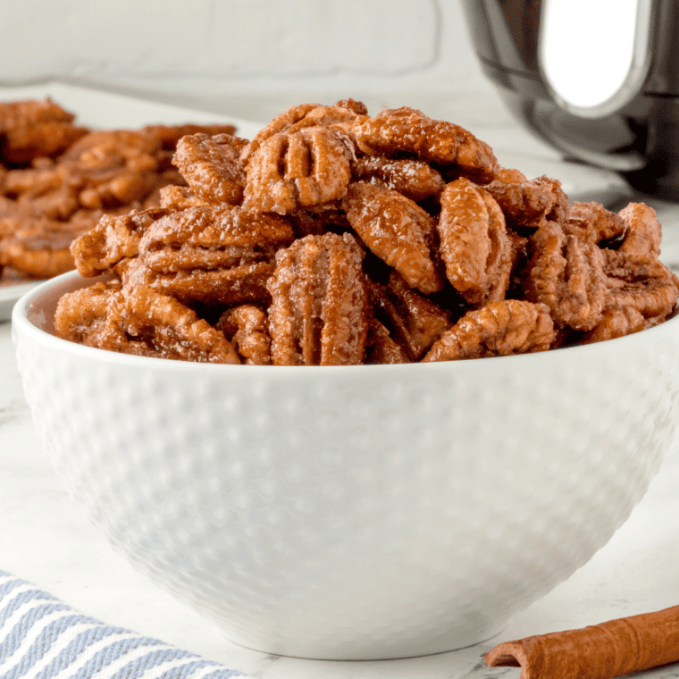 side view closeup: a white bowl full of air fried candied pecans