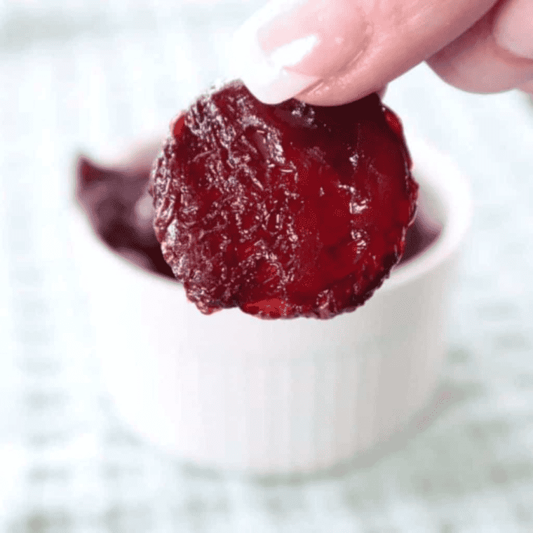 closeup: a hand holding an air fryer beet chip