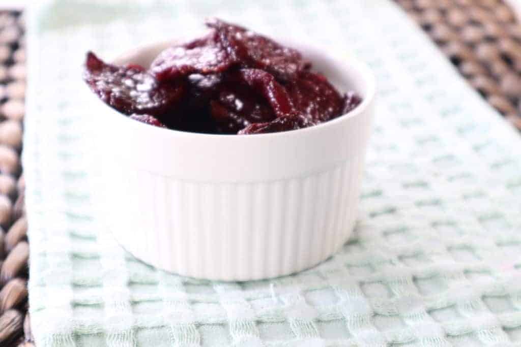 side view: air fryer beet chips in a small white ramekin