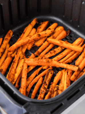 A plate of crispy, golden Air Fryer Carrot Fries, seasoned to perfection and served with a side of dipping sauce.