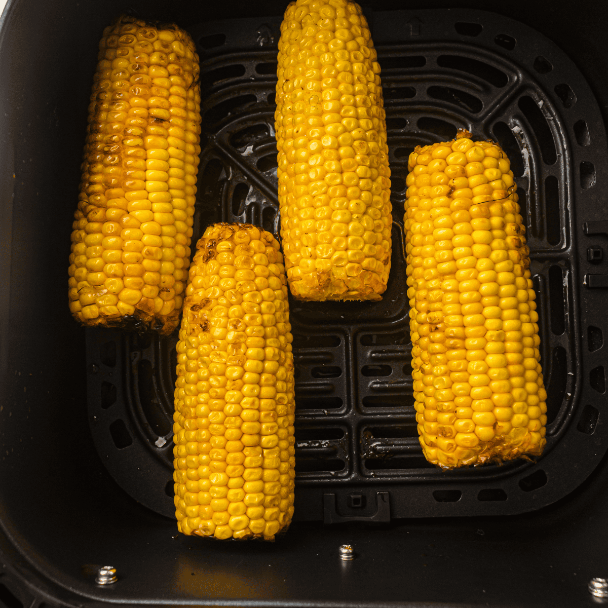 Golden, perfectly cooked Air Fryer Corn on the Cob, ready to be served with a buttery topping.