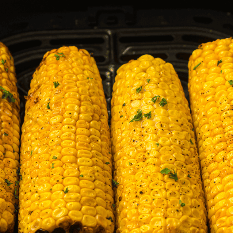Golden, perfectly cooked Air Fryer Corn on the Cob, ready to serve with a buttery topping.