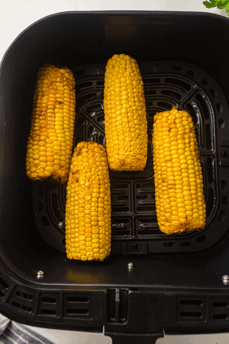 Golden, perfectly cooked Air Fryer Corn on the Cob, served with butter and seasonings.