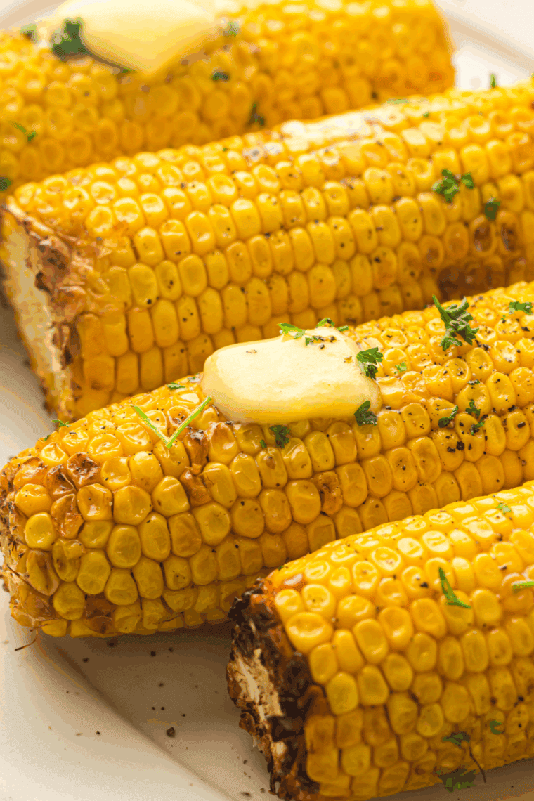 Golden, crispy Air Fryer Corn on the Cob served with butter and seasoning.