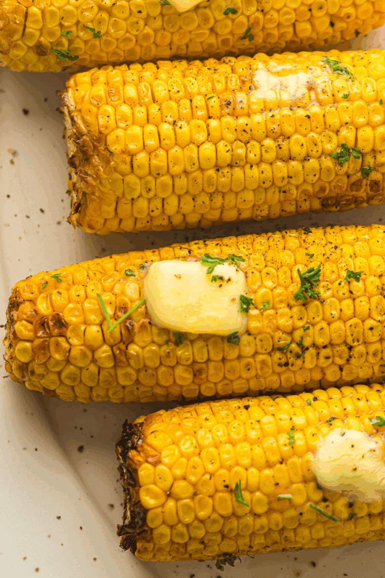 Golden, crispy Air Fryer Corn on the Cob served with butter and seasoning.