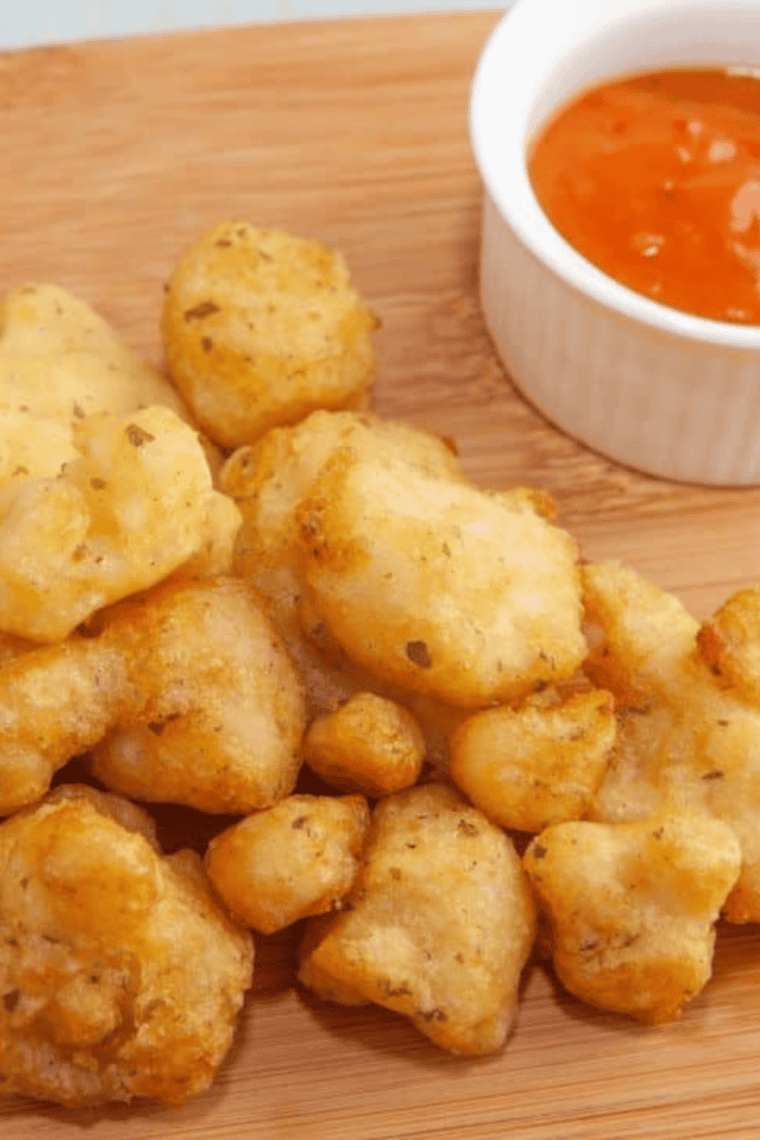 Golden, crispy air fryer frozen battered cauliflower served hot with dipping sauce.