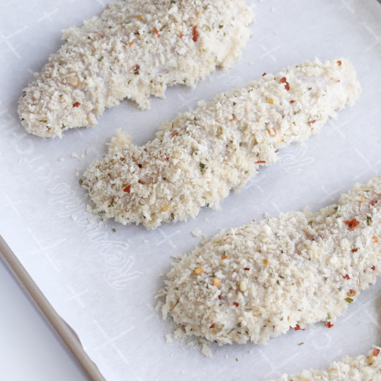 Coated chicken tenders on parchment, while you continue breading the rest.