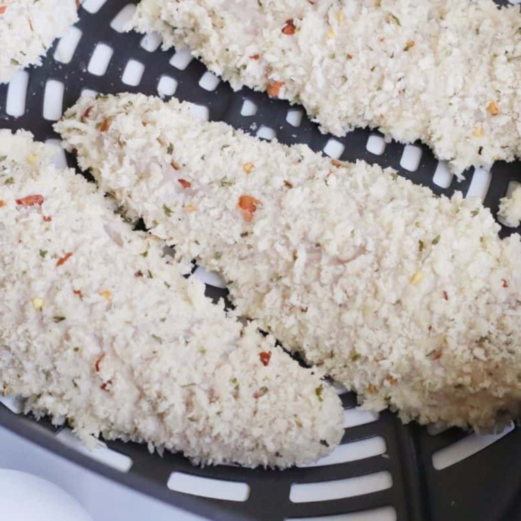 Place the raw chicken tenders into the air fryer basket.