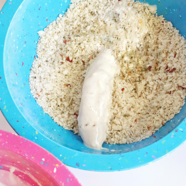 Dipping the chicken tenders into the bread crumb mixture.