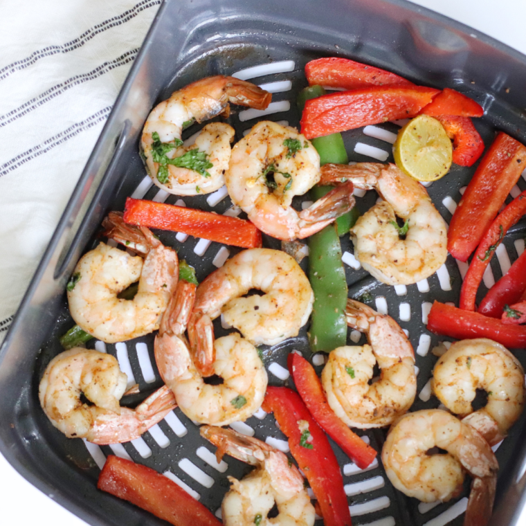 "Colorful shrimp fajitas with bell peppers cooked in an air fryer, served with tortillas."