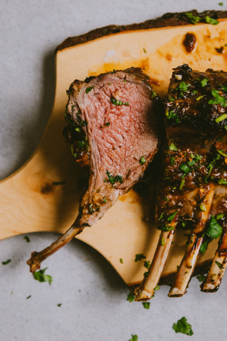 Juicy lamb chops coated in garlic butter cooking on a Blackstone griddle.