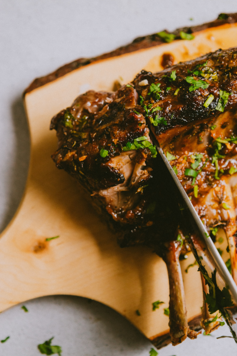Blackstone garlic butter lamb chops sizzling on a hot griddle with melted butter and herbs.