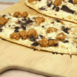 Blackstone griddle cooking a sausage and mushroom flatbread pizza with crispy crust and melted cheese.