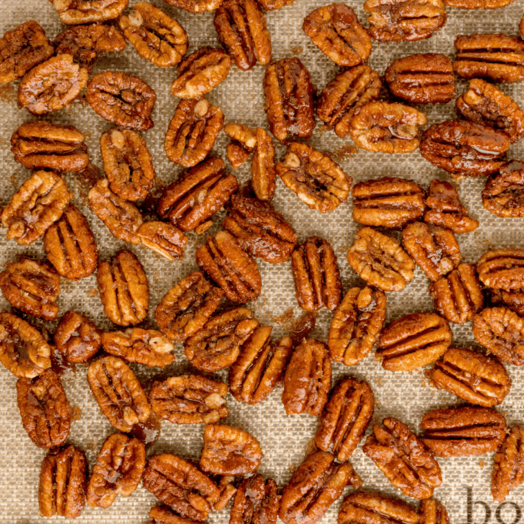 overhead closeup: candied pecans from air fryer cooling on silpat