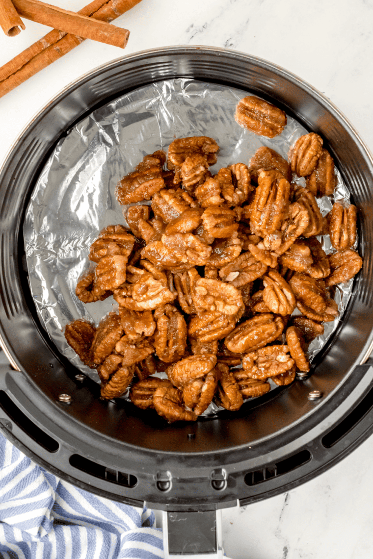 overhead process shot: candied pecans in an air fryer basket