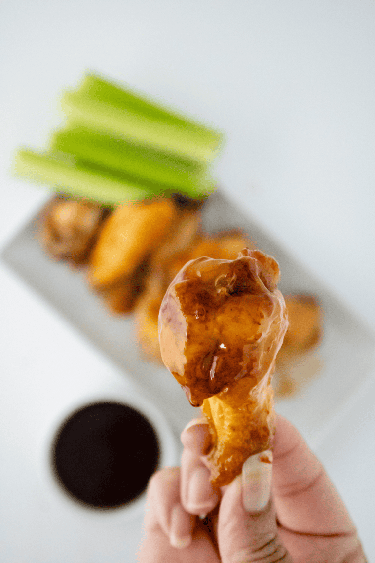 Plate of crispy chicken wings coated in sweet and tangy Hawaiian sauce, served hot and ready to eat.