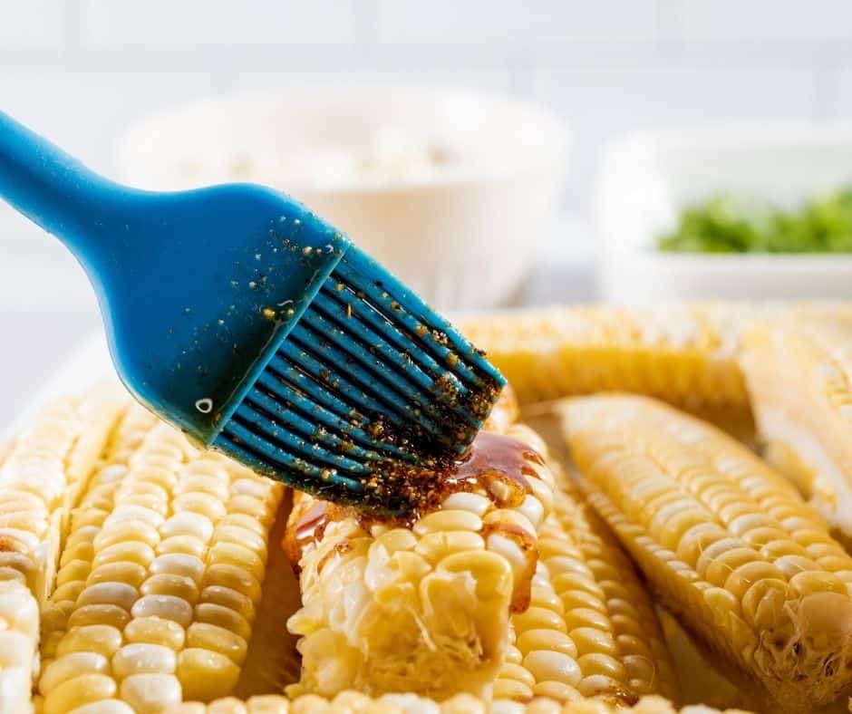 Take each ear of corn, stand up vertically, and carefully cut in half straight down with a large, sharp knife. Do this again until each ear of corn is in quarters, lengthwise. Use a pastry brush to coat corn liberally with oil mixture on all sides.