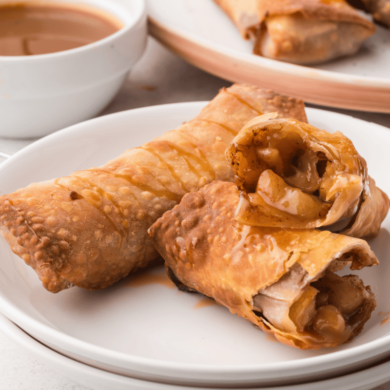 Golden, crispy Air Fryer Apple Pie Egg Rolls filled with sweet apple cinnamon filling and drizzled with caramel.