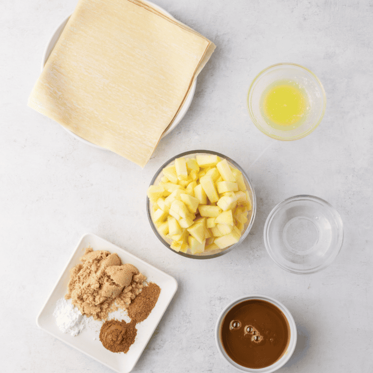 Ingredients needed for Apple Pie Egg Rolls Recipe on kitchen table.