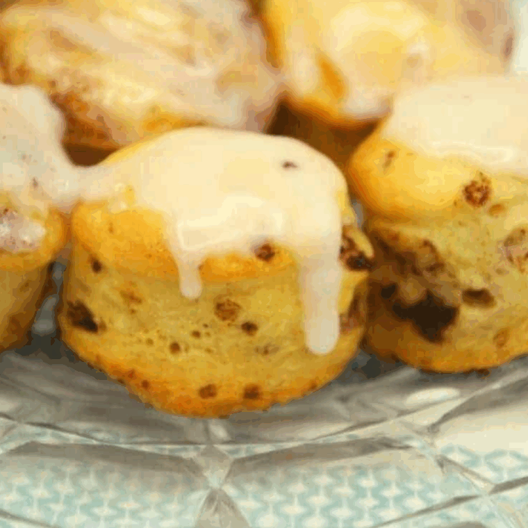 Golden, bite-sized cinnamon roll bites cooked in an air fryer and drizzled with glaze.
