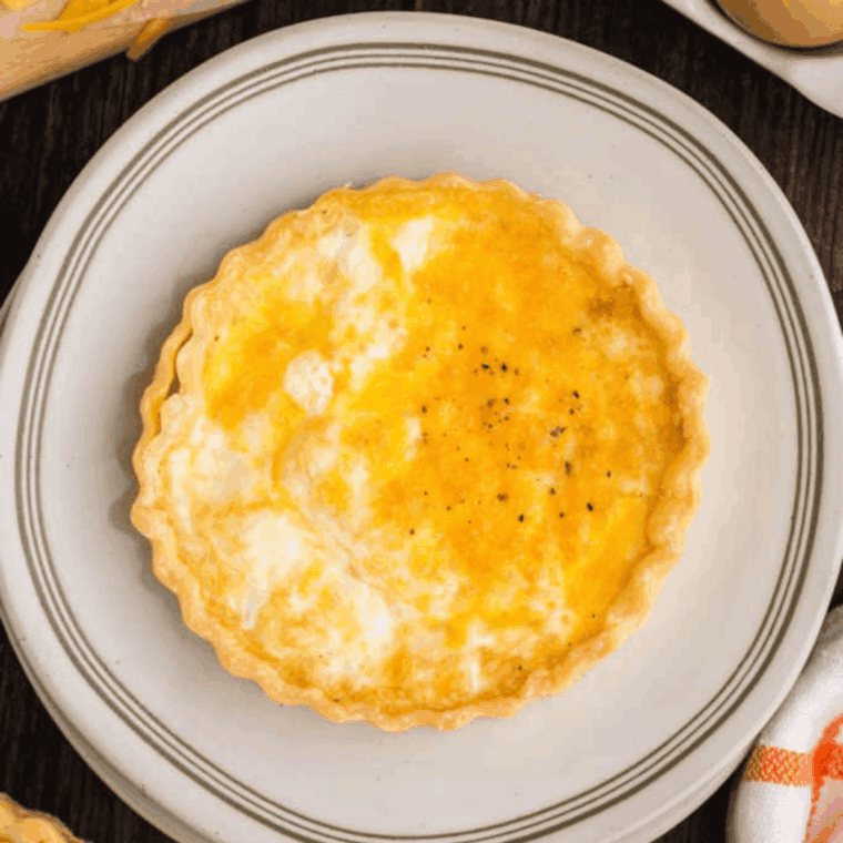 Air fryer basket with golden, cooked frozen quiche ready to serve
