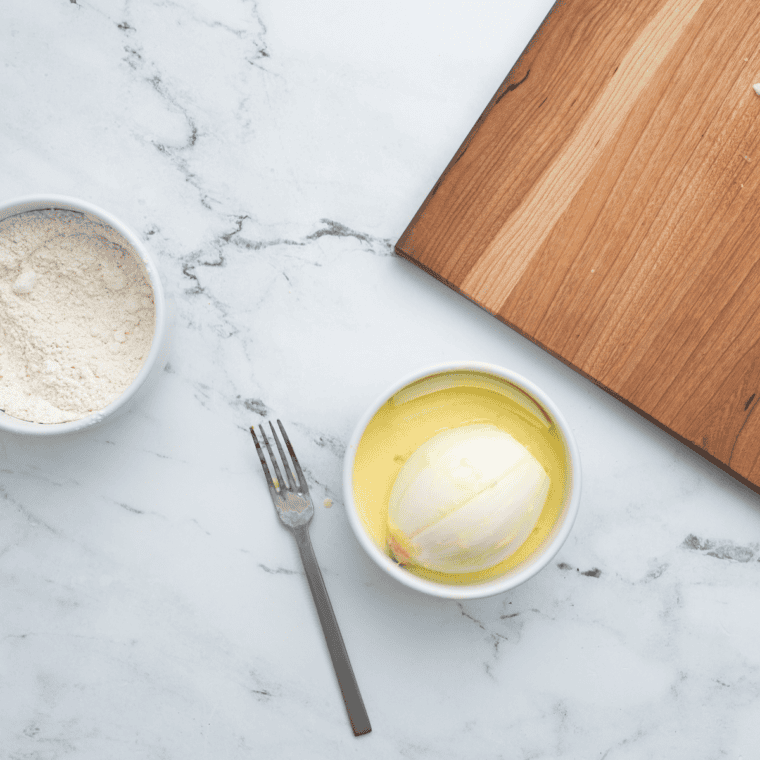 Whisking eggs and buttermilk together in a medium bowl to prepare coating for blooming onion