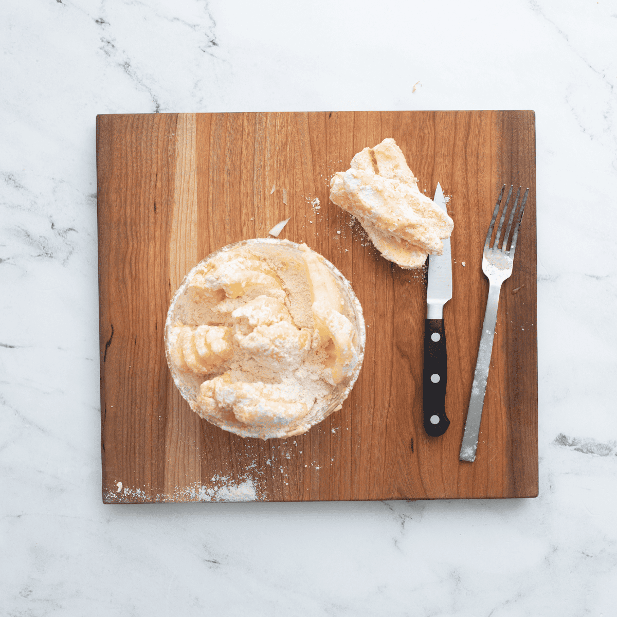 Coating an onion in buttermilk mixture and seasoned flour, making sure to cover all petals for a blooming onion