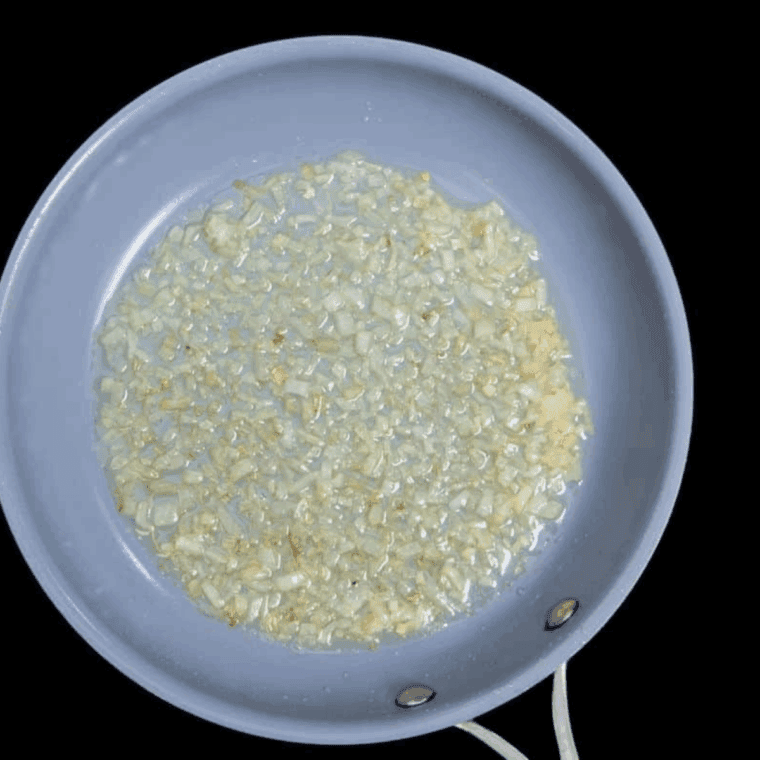 Sautéing diced onions and garlic in olive oil in a small skillet until soft and fragrant.