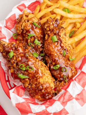 Crispy golden chicken tenders made in air fryer with pickle brine seasoning served on plate with dipping sauce.