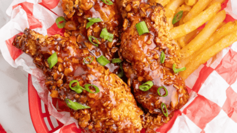 Crispy golden chicken tenders made in air fryer with pickle brine seasoning served on plate with dipping sauce.