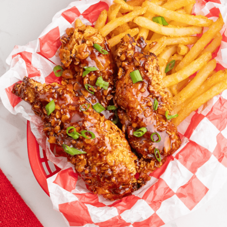 Golden crispy air fryer chicken tenders marinated in pickle brine, served on a plate with dipping sauce.