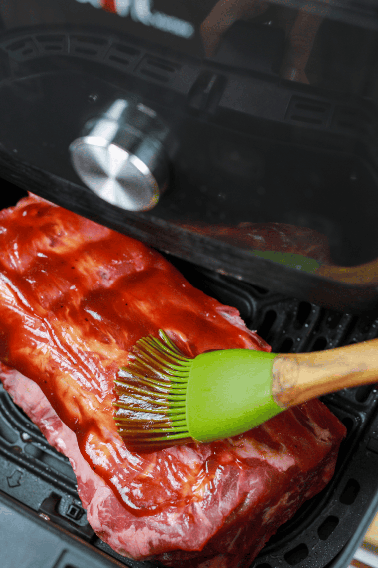 Rib sections placed in a single layer in an air fryer basket.