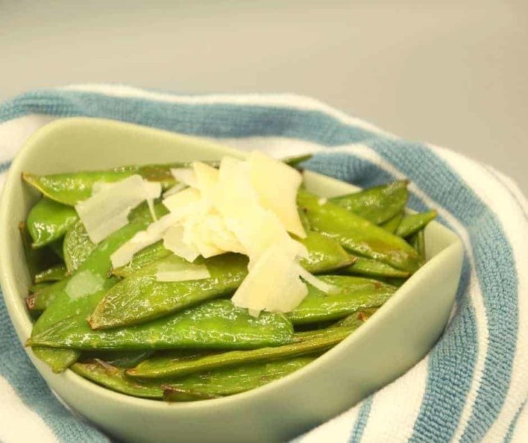 closeup: a bowl of air fryer sugar snap peas with parmesan on top