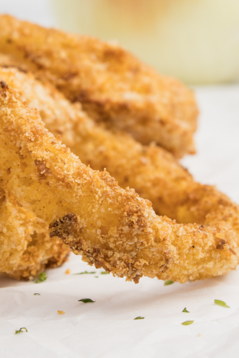 Close up of frozen onion rings sizzling on a Blackstone outdoor griddle