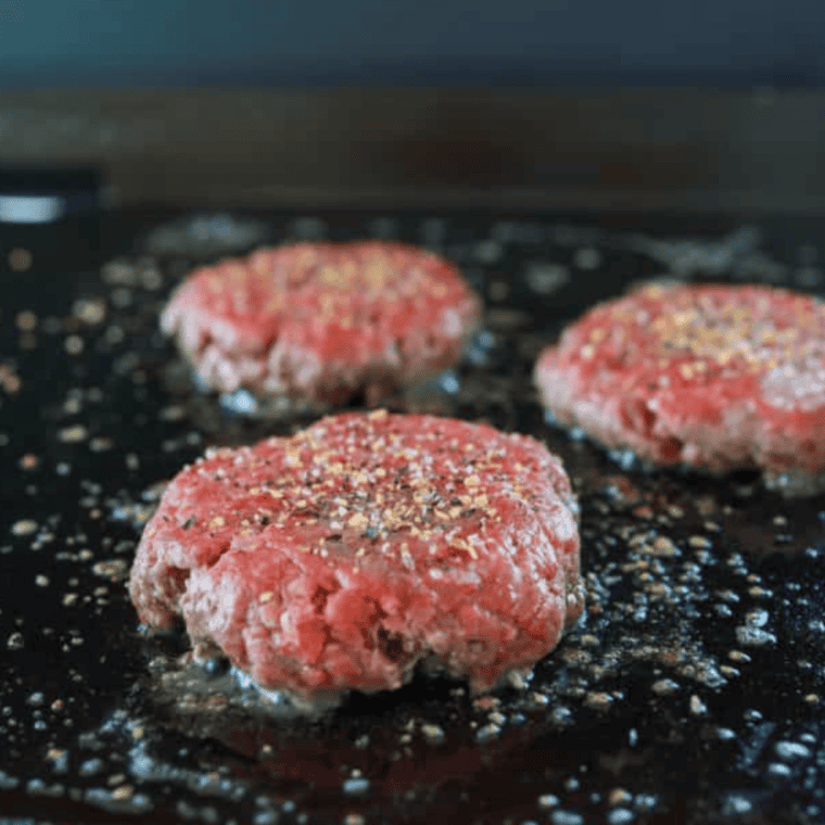 Heat griddle, season meat, smash burgers with wax paper.