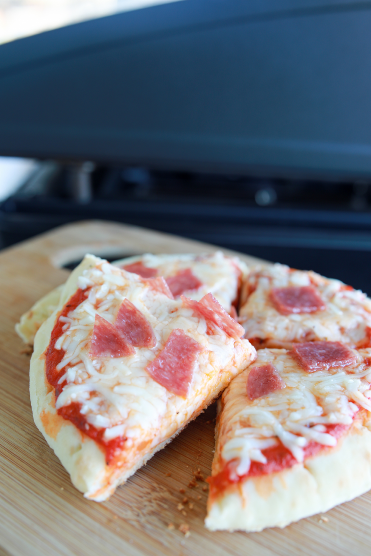 Homemade pepperoni pizza on a Blackstone flat top griddle with golden crust and melted cheese.