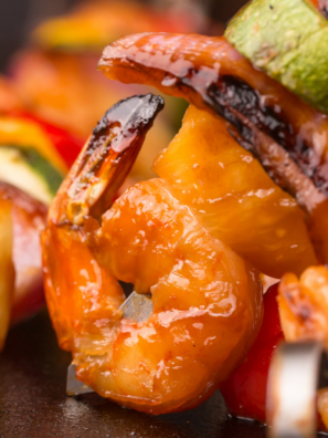 Blackstone garlic butter shrimp sizzling on griddle with lemon and parsley