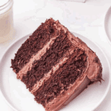 Slice of Cheesecake Factory Linda’s Fudge Cake with thick fudgy frosting and moist chocolate cake layers.