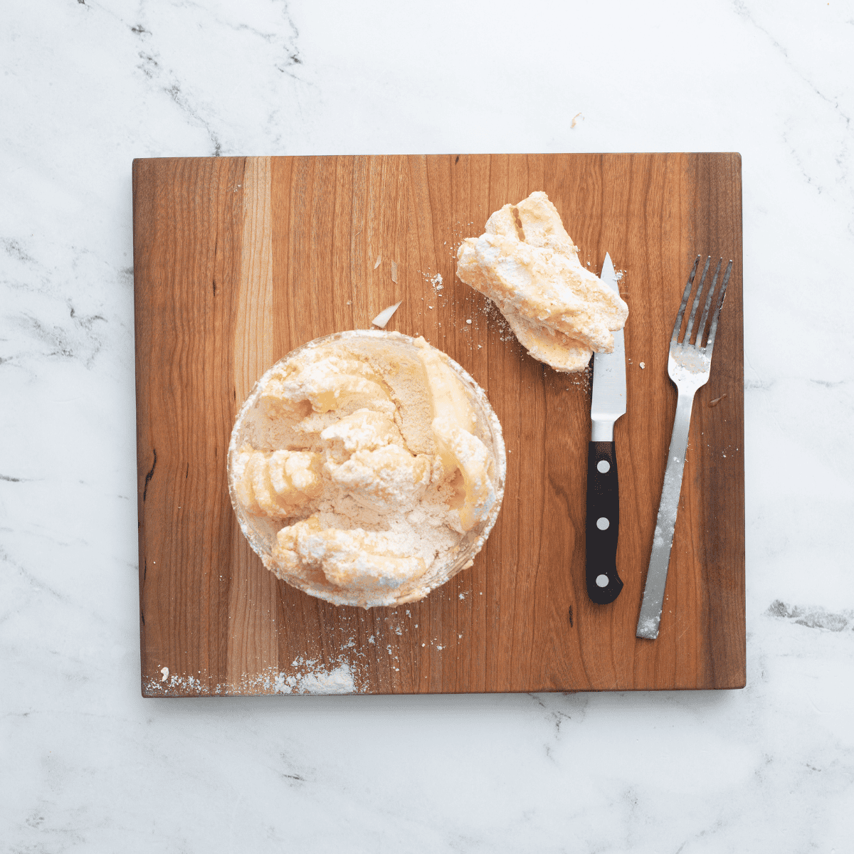 Coating an onion in buttermilk mixture and seasoned flour, making sure to cover all petals for a blooming onion
