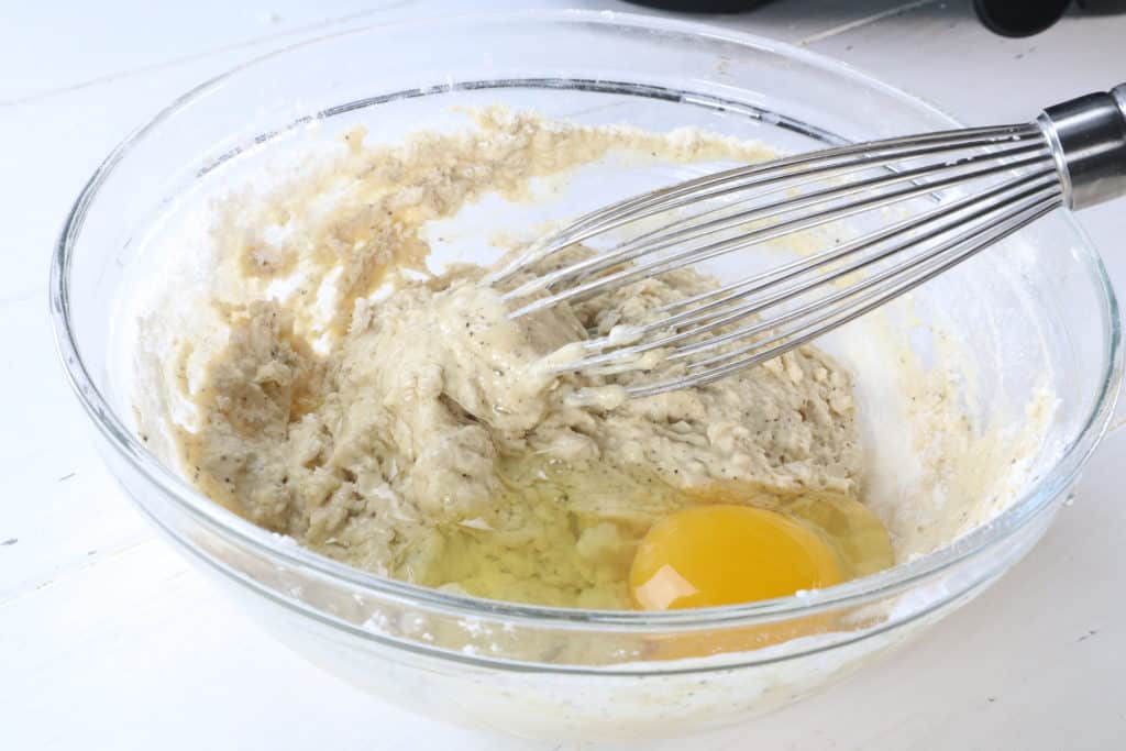 In another bowl, add the water, 1 egg, mustard, garlic powder, onion powder, ground pepper, and flour. Mix well.