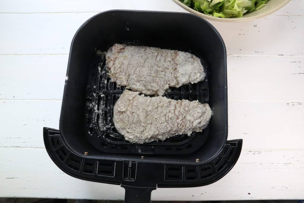 Add your coated chicken into the air fryer basket, spray generously with cooking spray. Set the temperature to 360 degrees F, air fryer setting, for 12 to 15 minutes, flipping halfway.